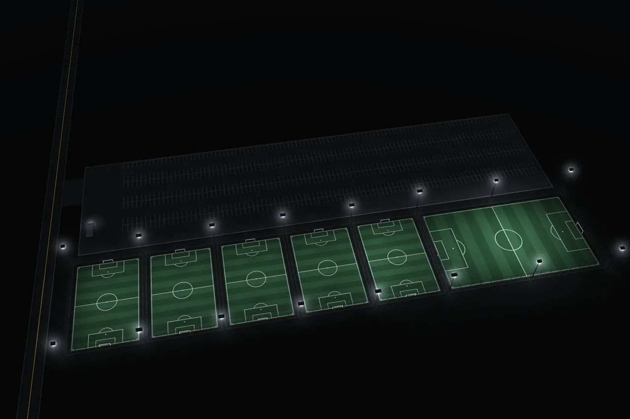 Stylized night map of the facility: Uvalde Rd along the west side, the entrance drive into the parking lot across the north, the check-in booth at the west end of the lot, and one row of lit, caged turf fields south of the lot with the larger premium field at the east end.